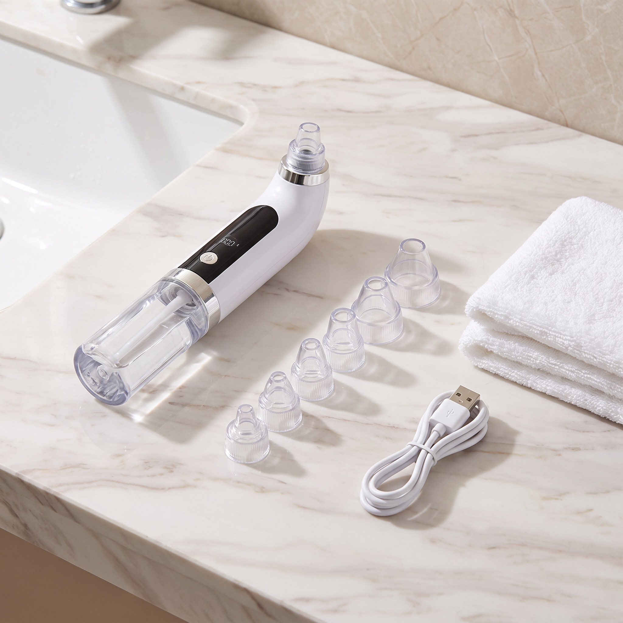 Amora Pore Cleansing Vacuum on a marble counter with its six suction heads laid out in a row